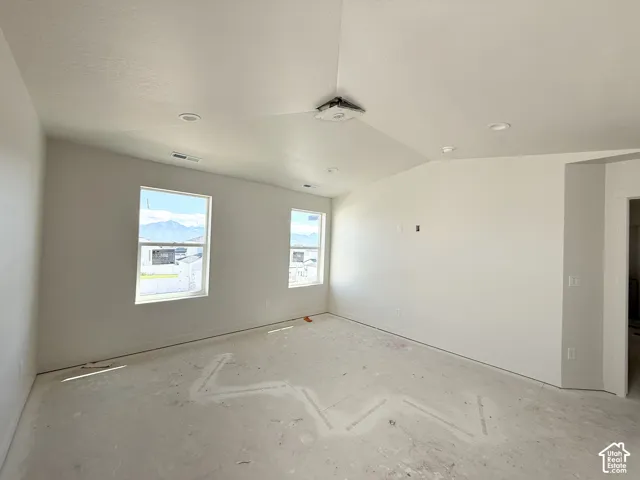 Vaulted ceiling, two windows, recessed lighting, and a white interior