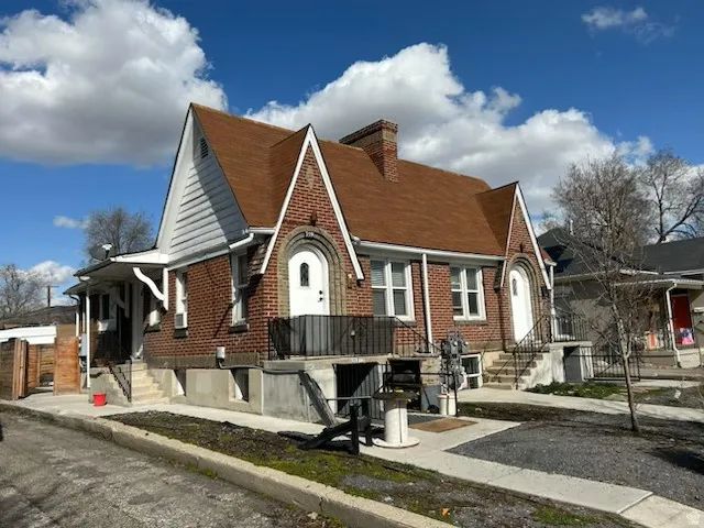Brick exterior featuring multiple gables, brown shingle roof, and white accent siding