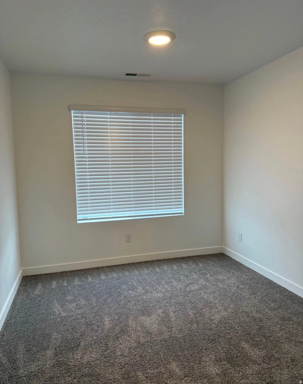 Recessed ceiling lighting, window with blinds, and neutral tone walls