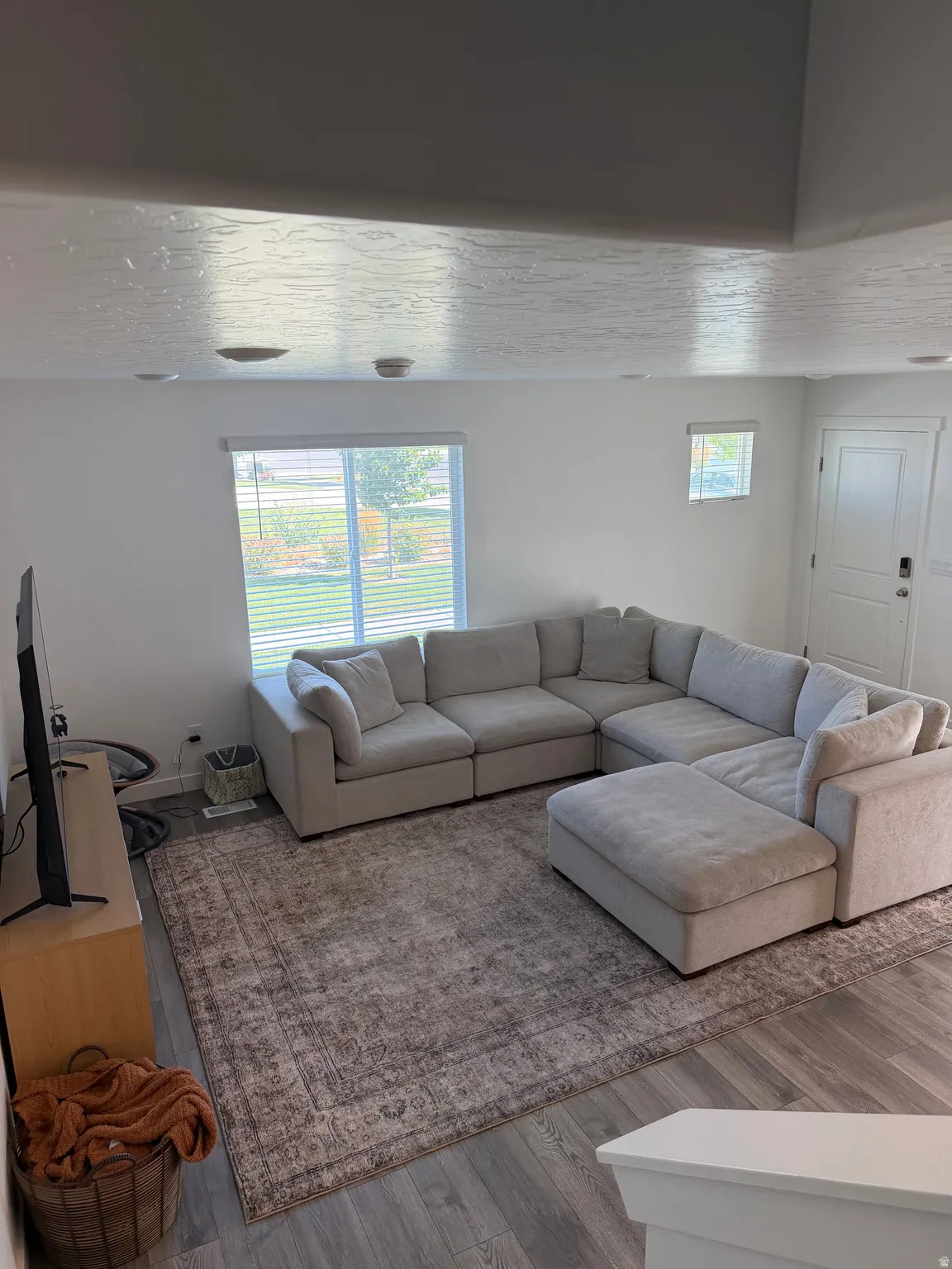 Wood-finish flooring, recessed lighting, and expansive windows with blinds
