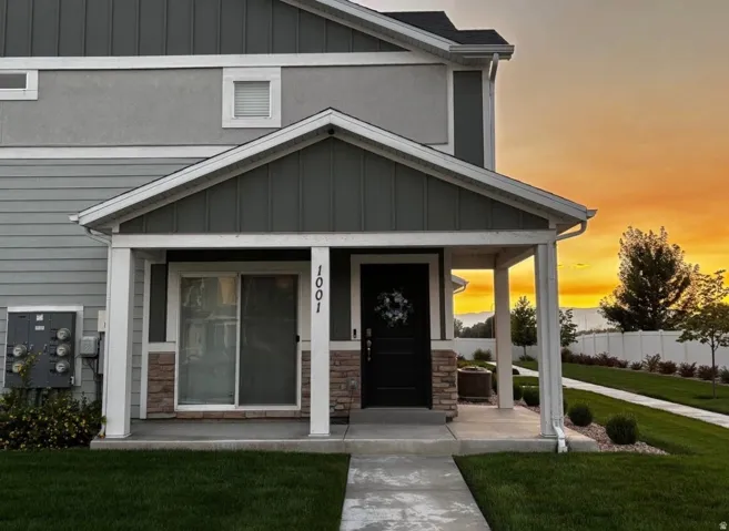 Covered entryway featuring a dark entry door and stone accents
