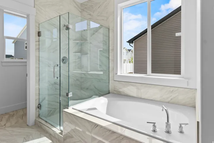Integrated soaking tub and walk-in shower with clear glass enclosure