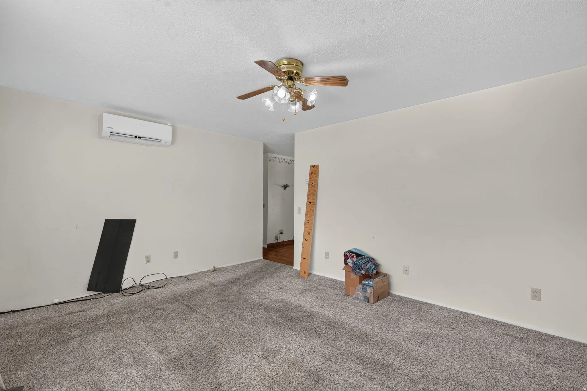 Ceiling fan with light fixture, wall-mounted climate control unit, and textured ceiling