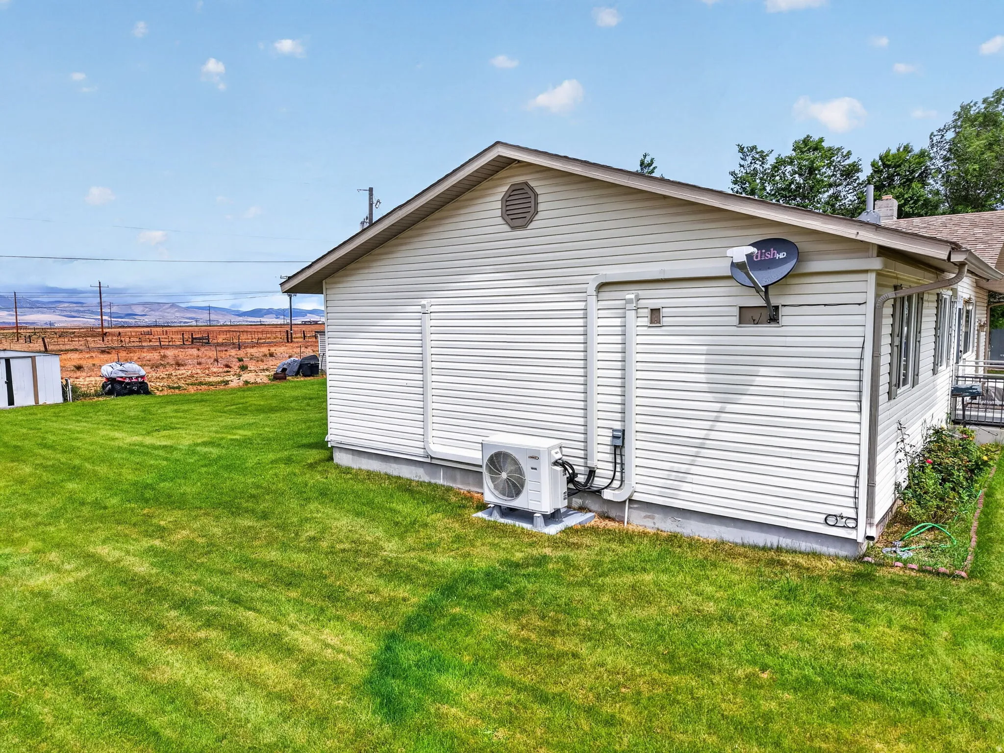 White vinyl siding exterior with a pitched roof and an HVAC unit