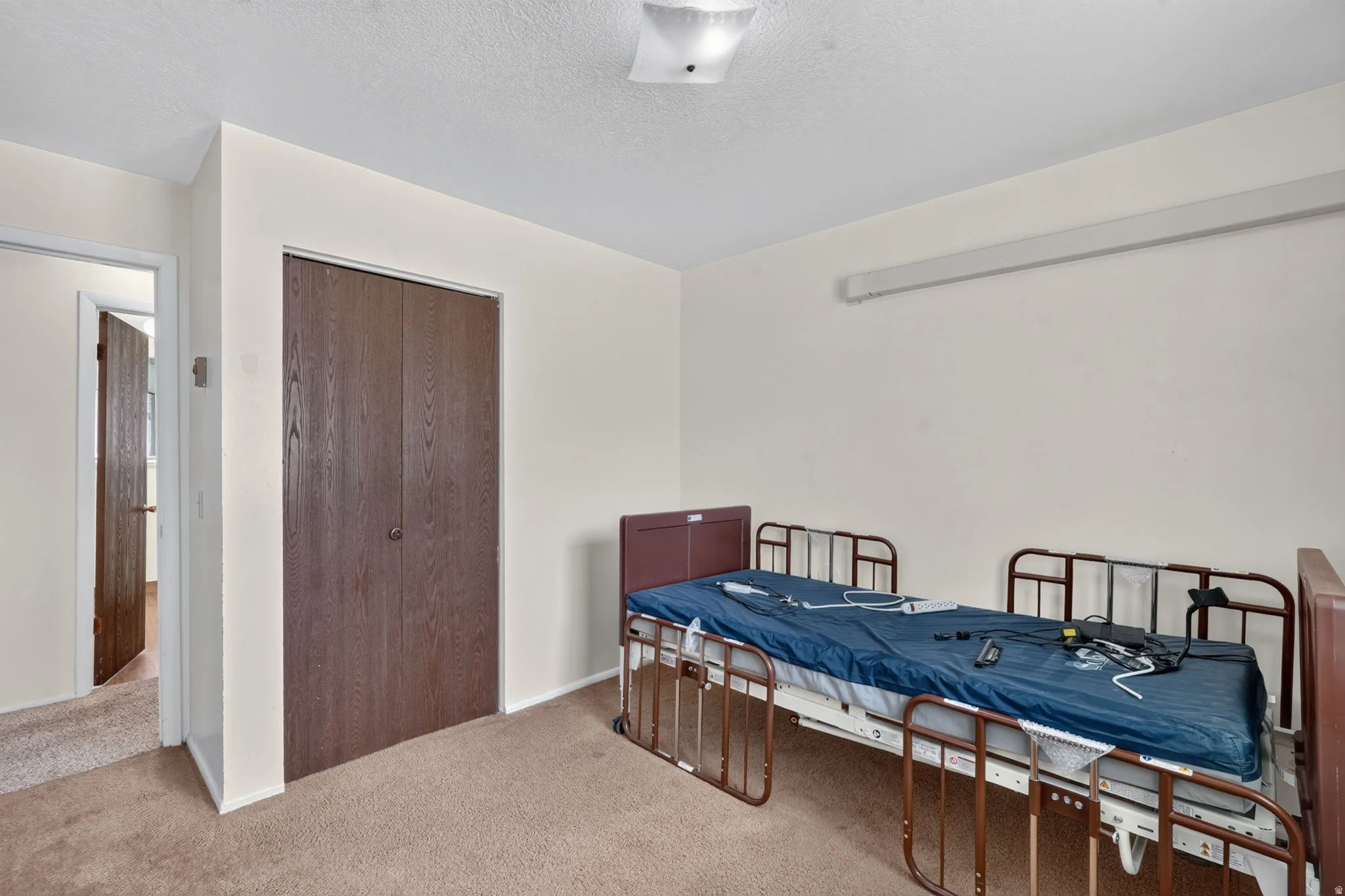 Neutral wall paint, textured ceiling, flush mount ceiling light, and bi-fold closet doors