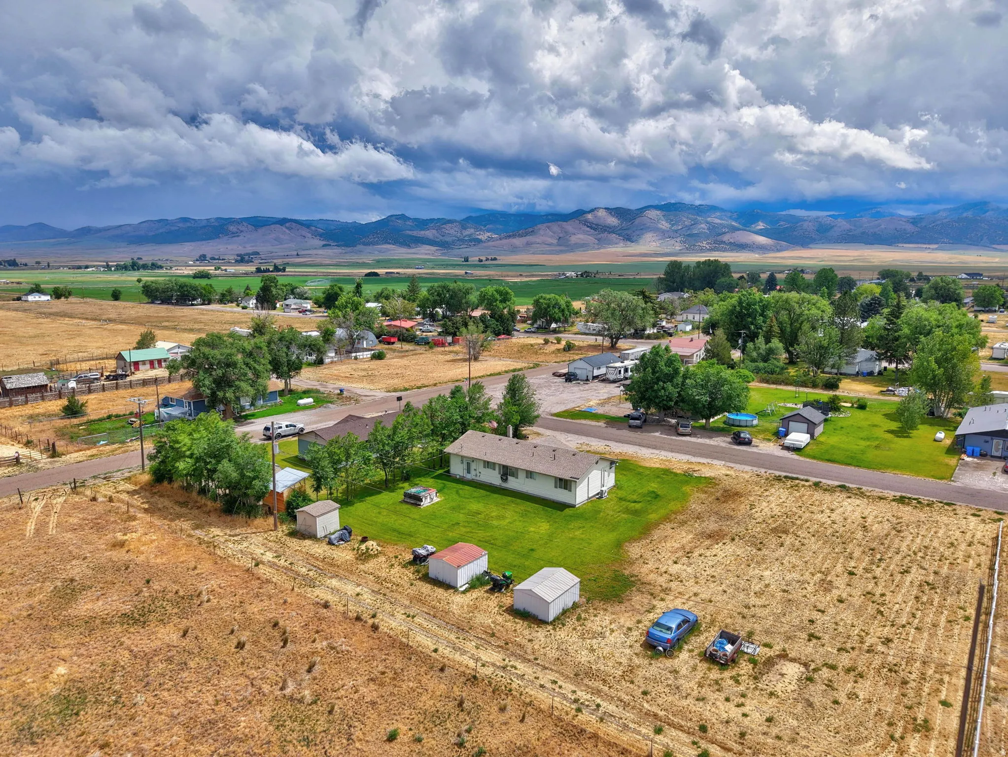 Expansive property featuring a single-story residence, multiple outbuildings, and a large open lot