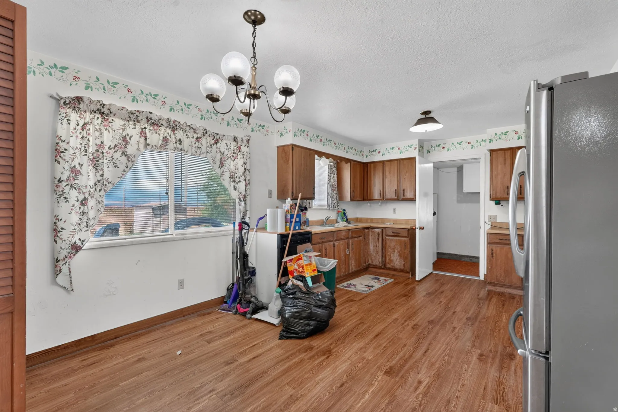 Kitchen area featuring wood-finish flooring, wood cabinetry, and a ceiling-mounted light fixture