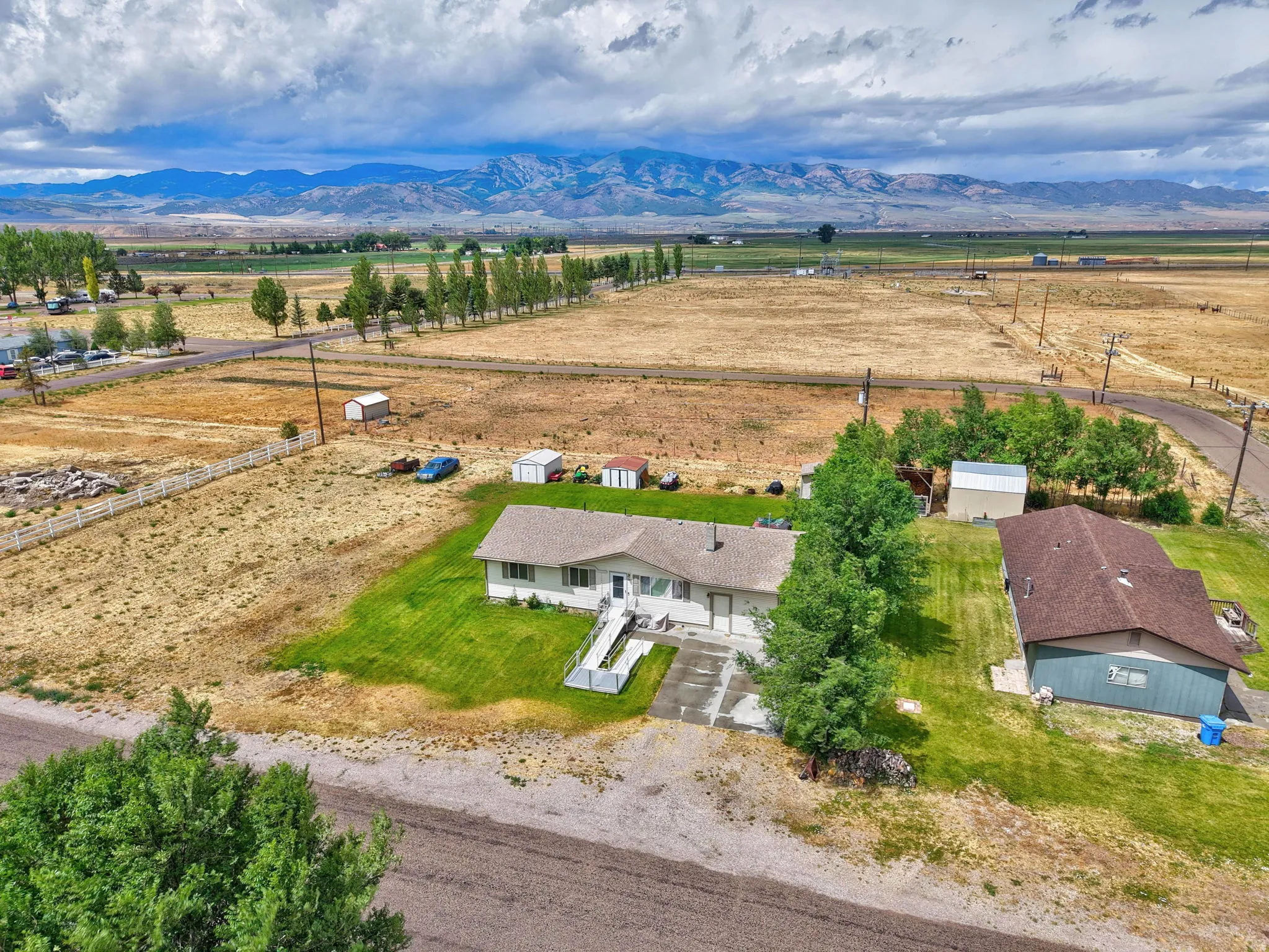Ranch-style residence with an attached garage, featuring a well-maintained lawn and mature trees