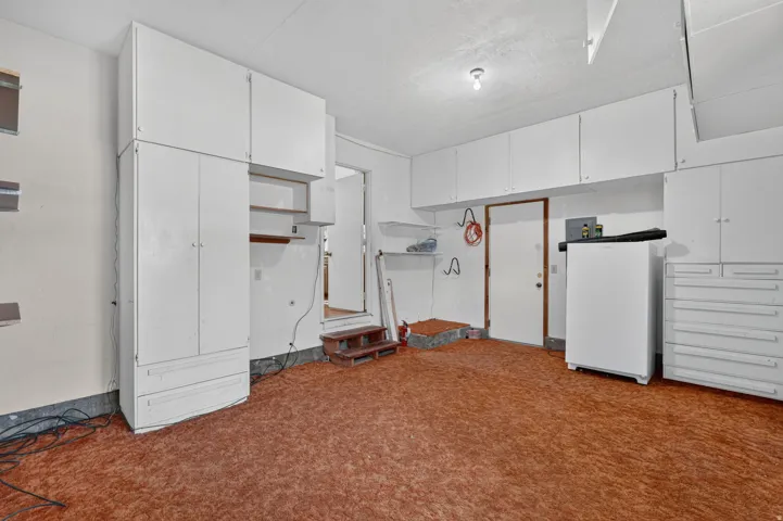 Extensive built-in white cabinetry, additional built-in white storage drawers, and wall-mounted shelving