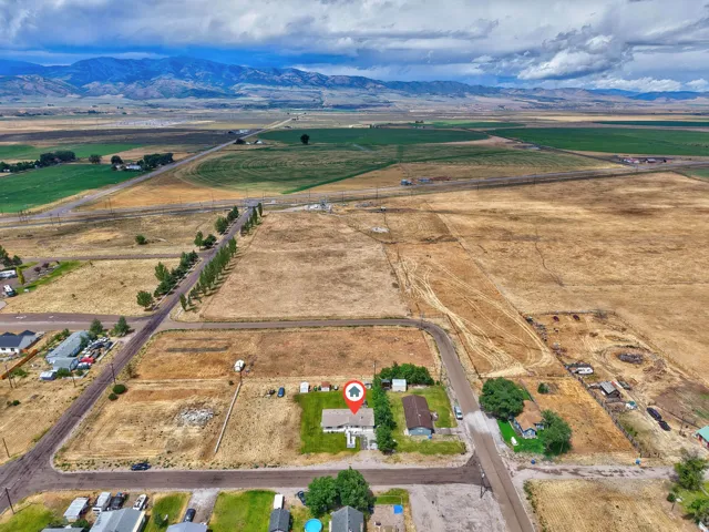 Expansive rural setting with mountain backdrop and surrounding agricultural fields