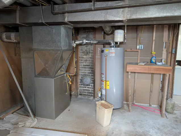 Galvanized ductwork with a water heater and an exposed brick accent wall