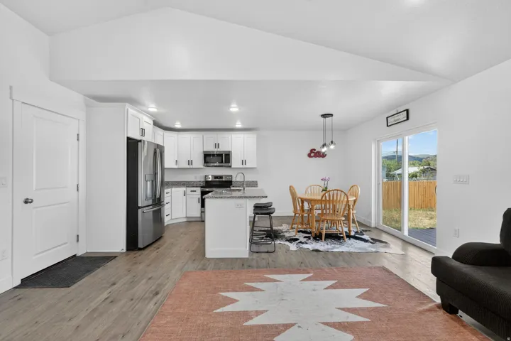 White kitchen cabinetry with stainless steel appliances, granite countertops, and a kitchen island