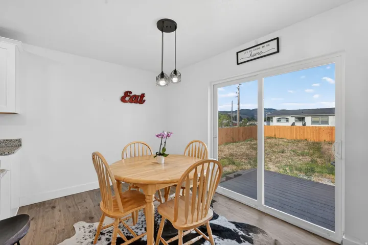 Bright dining area with sliding glass doors opening to a private outdoor deck and fenced yard