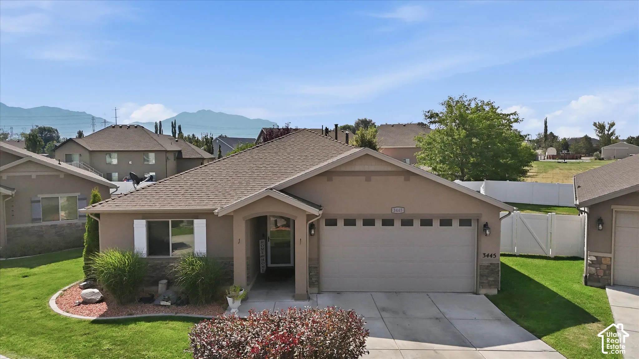 Single-story residence featuring a stucco exterior, attached two-car garage, and a covered entryway