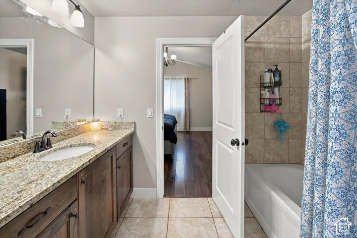 Double vanity with granite countertop, integrated sink, and dark wood-finish cabinetry