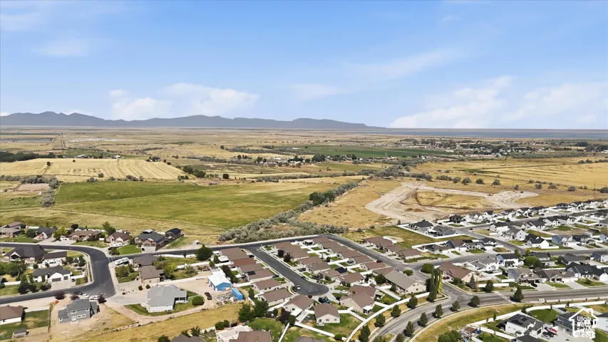 Expansive rural landscape with distant mountains and a residential development