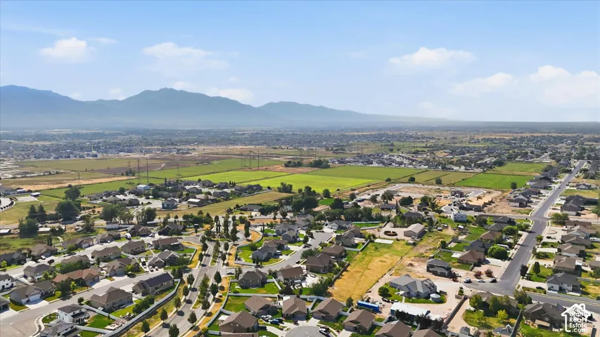 Residential area surrounded by open fields and distant mountains