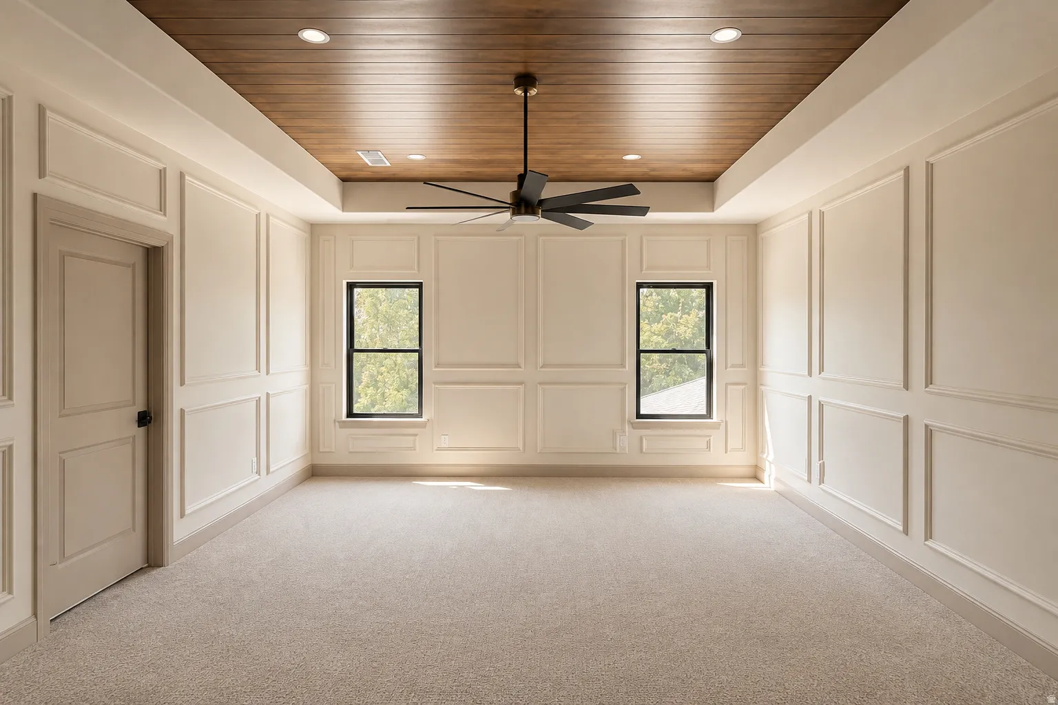 Primary Suite with wood-finish paneling in tray ceiling, wall moldings, and a new ceiling fan.