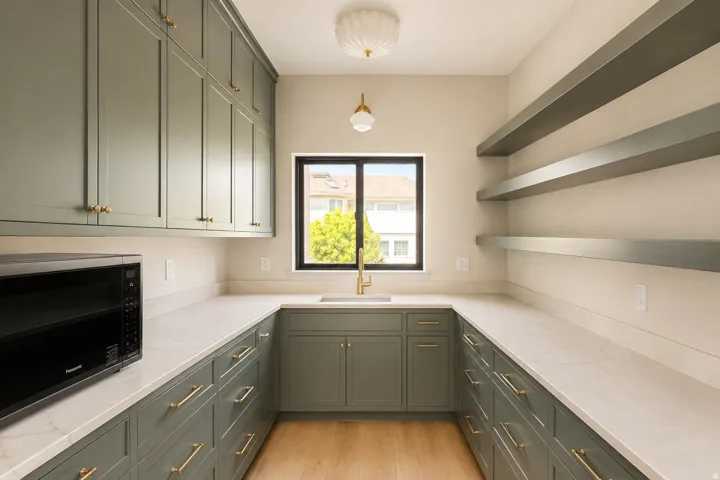 Pewter green cabinetry with gold accents and milk glass light fixtures.