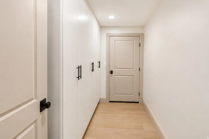 Storage space with built in cabinetry, and an entrance to the cold storage area.