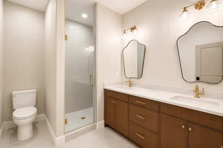 A brand new addition to this home is this shared bath with a wood double vanity and tile flooring.