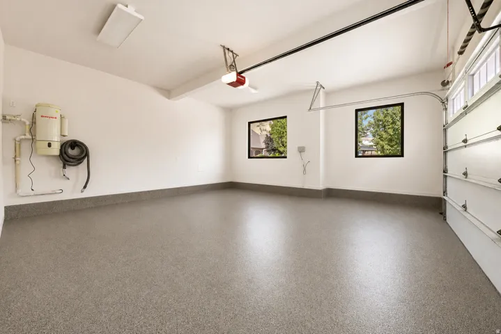 Two car garage with newly epoxy-coated flooring and natural lighting from two large windows.