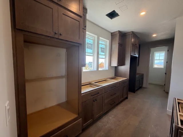 Dark wood-finish cabinetry, recessed lighting, and dual windows