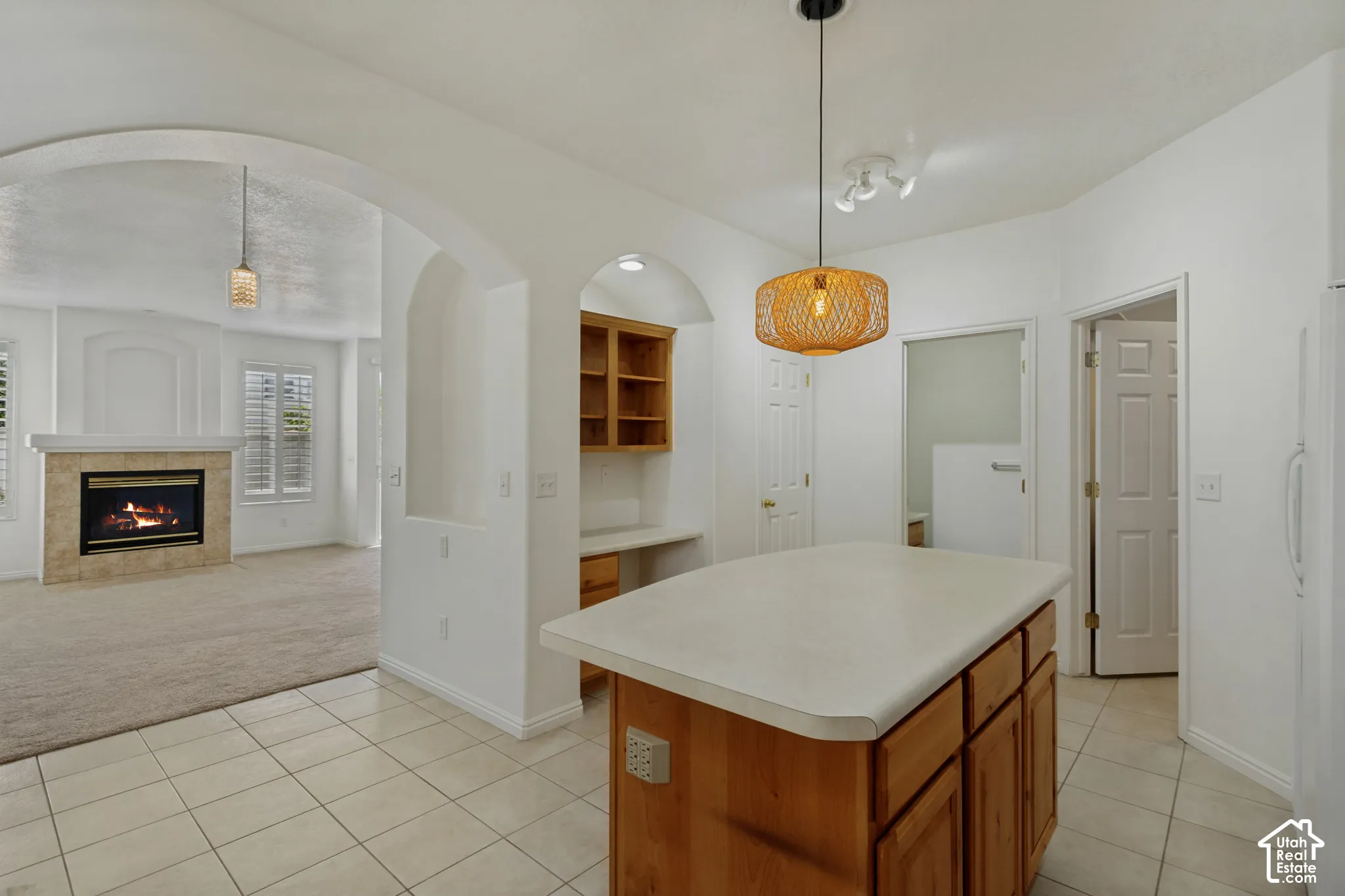 Kitchen island with light-toned wood cabinetry and a solid-surface countertop