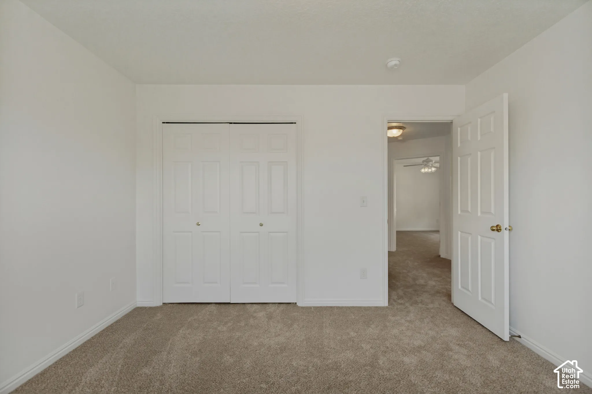 Neutral-toned carpet flooring, white walls, and white trim throughout