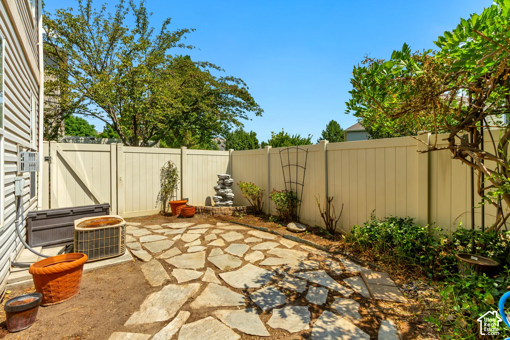 Flagstone patio area with a privacy fence and mature landscaping