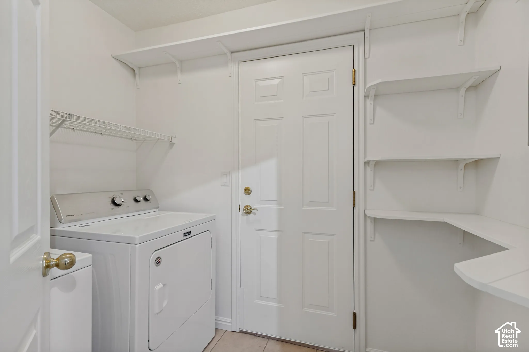 Utility area with white shelving units, wire rack storage, and a paneled door