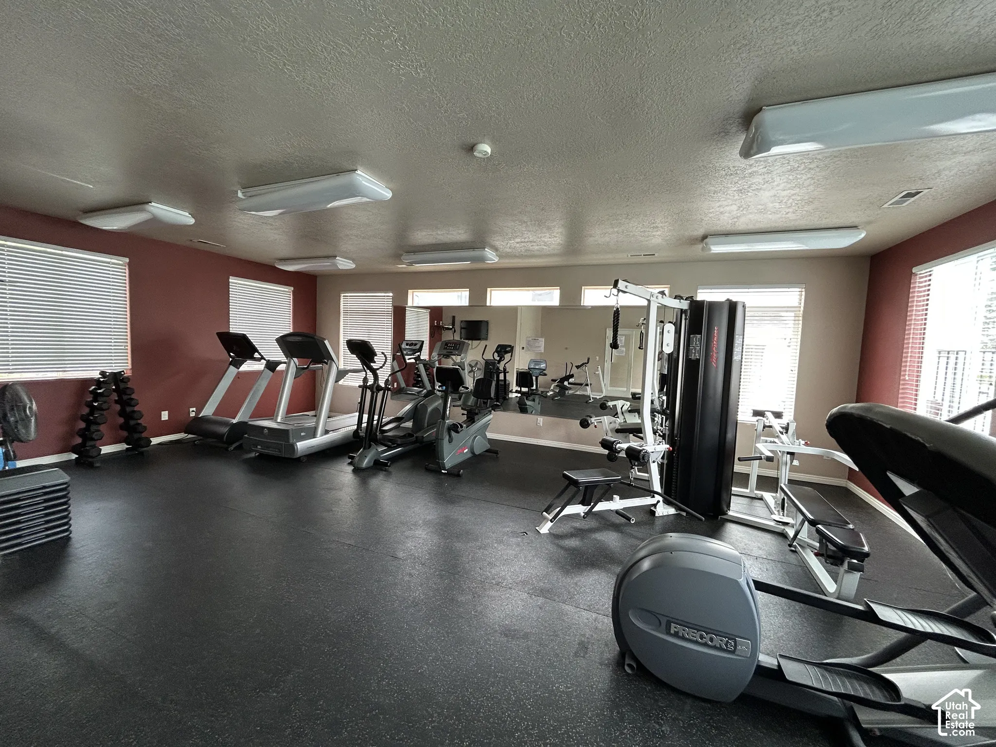 Dedicated fitness space featuring rubber flooring, extensive windows, and multiple overhead lighting fixtures