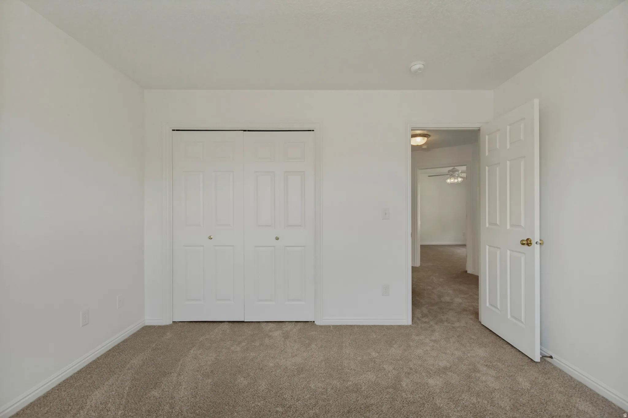 Neutral-toned carpet flooring, white walls, and white trim throughout