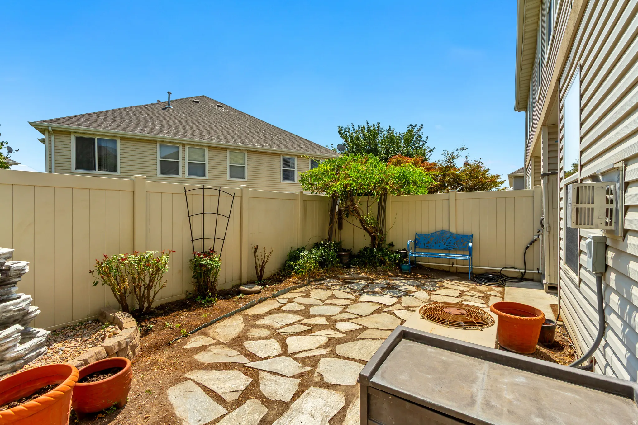 Private fenced yard featuring flagstone paving and a built-in fire pit