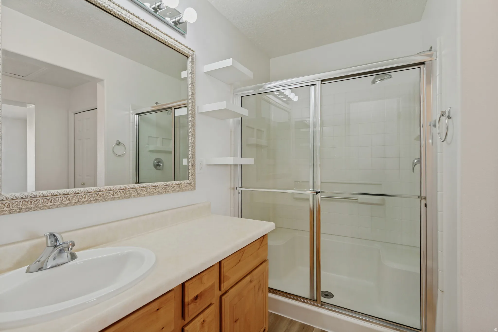 Bathroom vanity with an integrated sink, polished chrome faucet, and wood-finish cabinetry