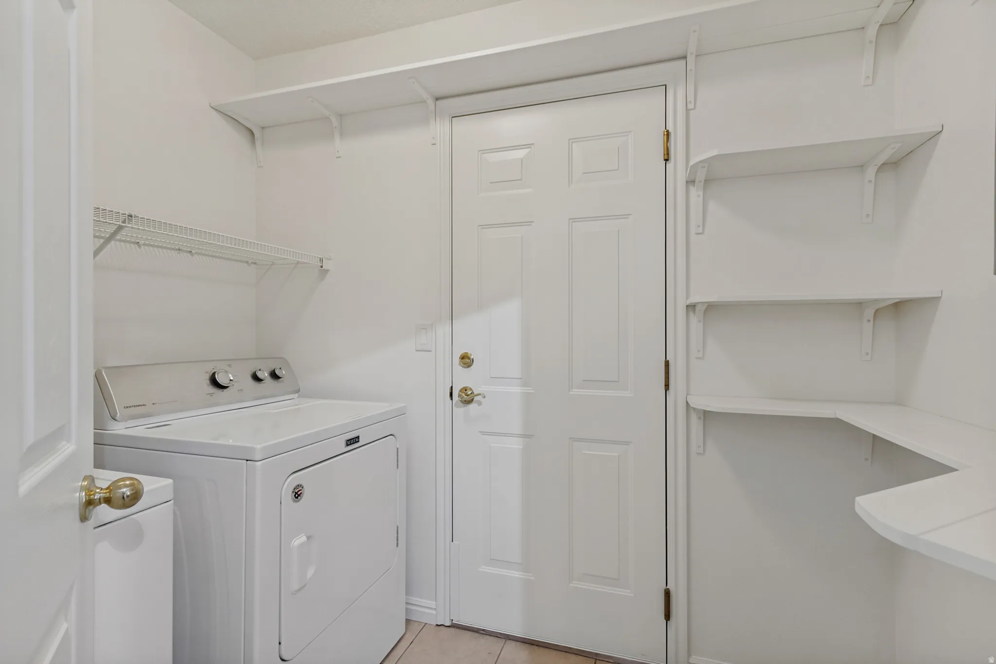 Utility area with white shelving units, wire rack storage, and a paneled door