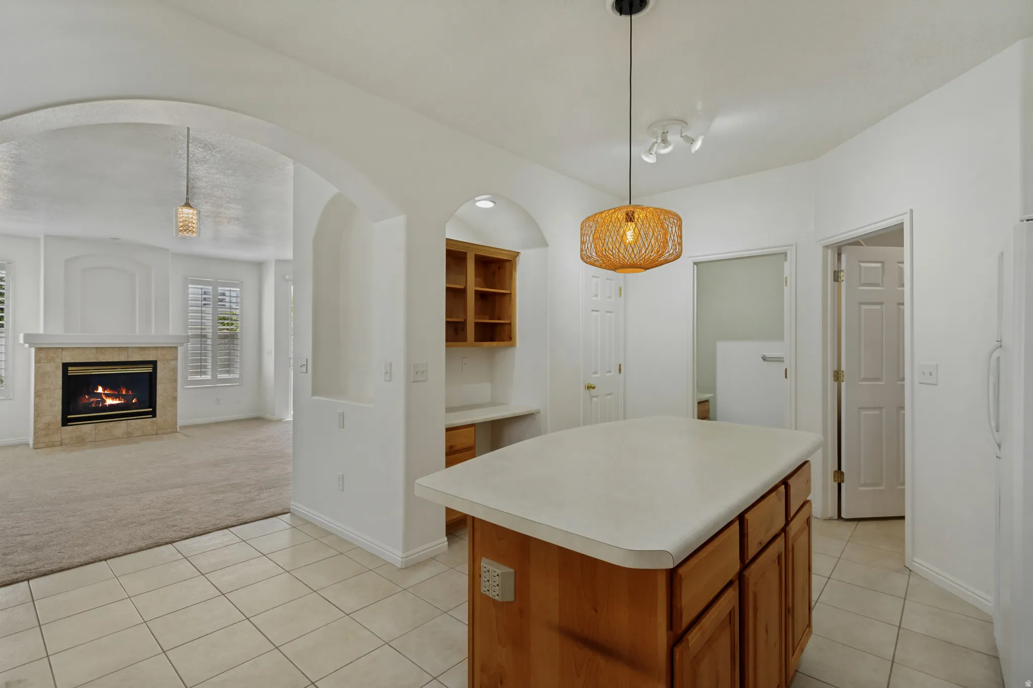 Kitchen island with light-toned wood cabinetry and a solid-surface countertop