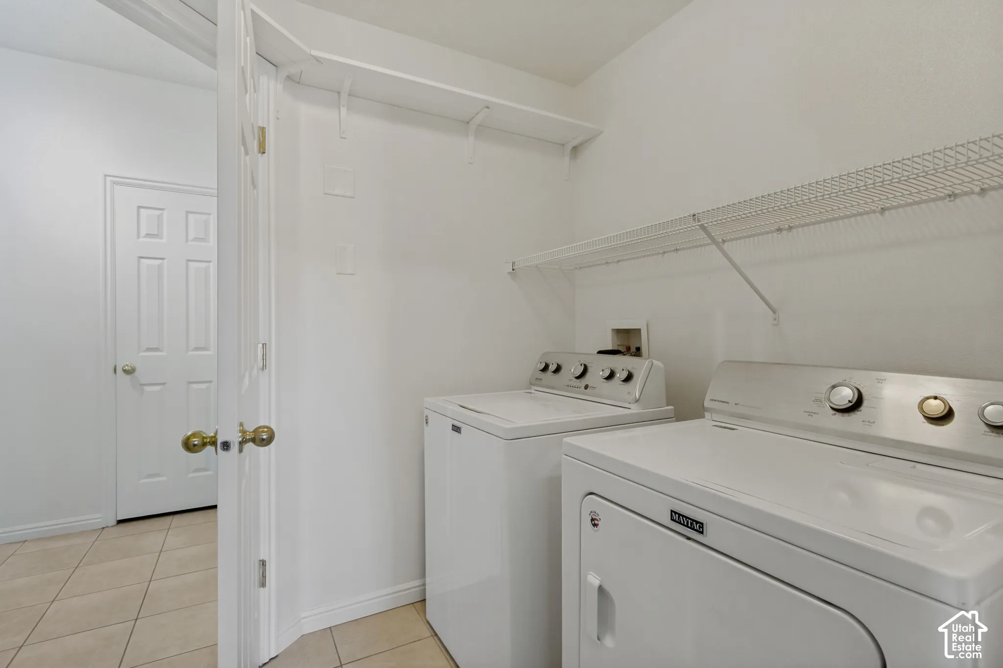 Laundry area featuring a top-load washing machine, front-load dryer, and wire shelving