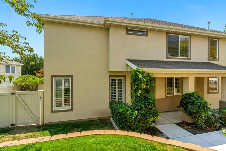Two-story stucco exterior with a dark shingle roof and covered entryway