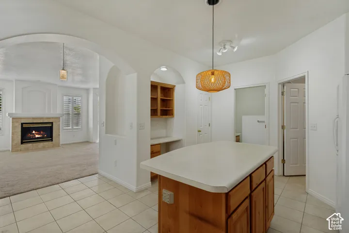 Kitchen island with light-toned wood cabinetry and a solid-surface countertop