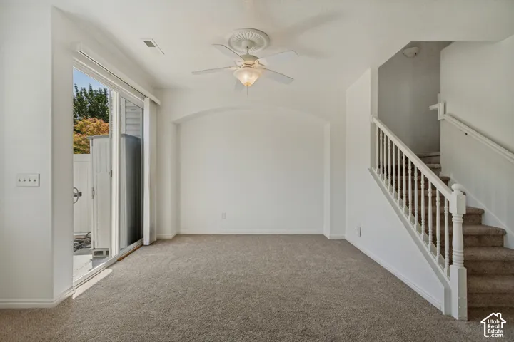 Neutral carpet flooring, white walls, and a ceiling fan with integrated lighting