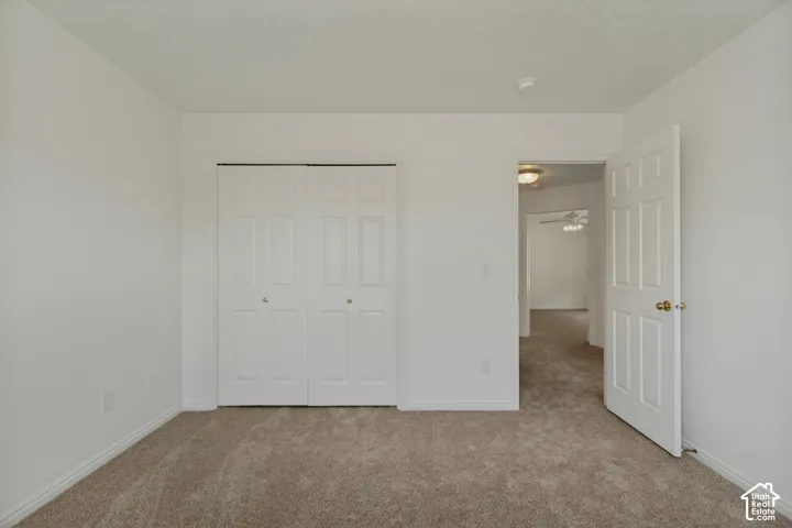 Neutral-toned carpet flooring, white walls, and white trim throughout