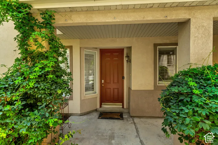 Covered entryway featuring a paneled door, exterior wall lantern, and concrete pathway