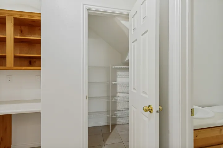 Built-in desk with wood-finish cabinetry, upper storage, and a solid surface countertop