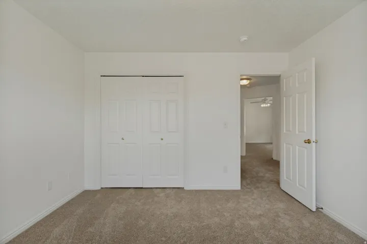 Neutral-toned carpet flooring, white walls, and white trim throughout
