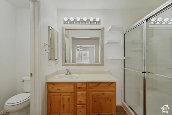 Vanity with integrated sink, natural wood-finish cabinetry, and framed mirror