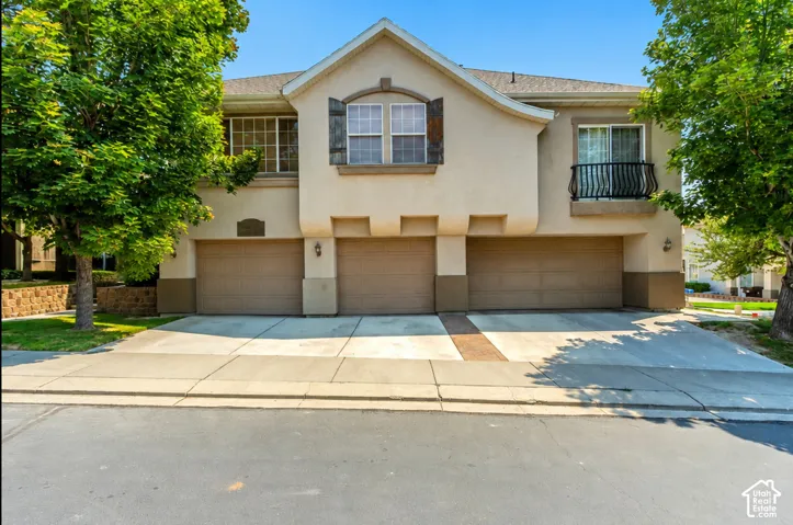 Stucco exterior with a tiled roof and multiple attached garages