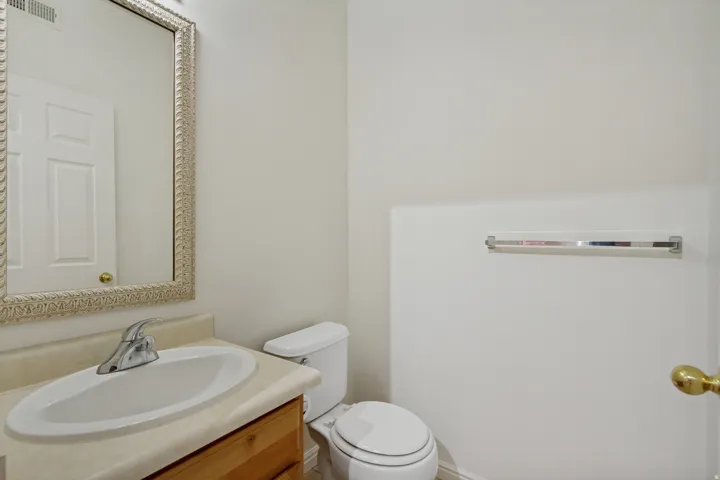 Vanity with an integrated oval sink, chrome faucet, and wood-finish cabinetry
