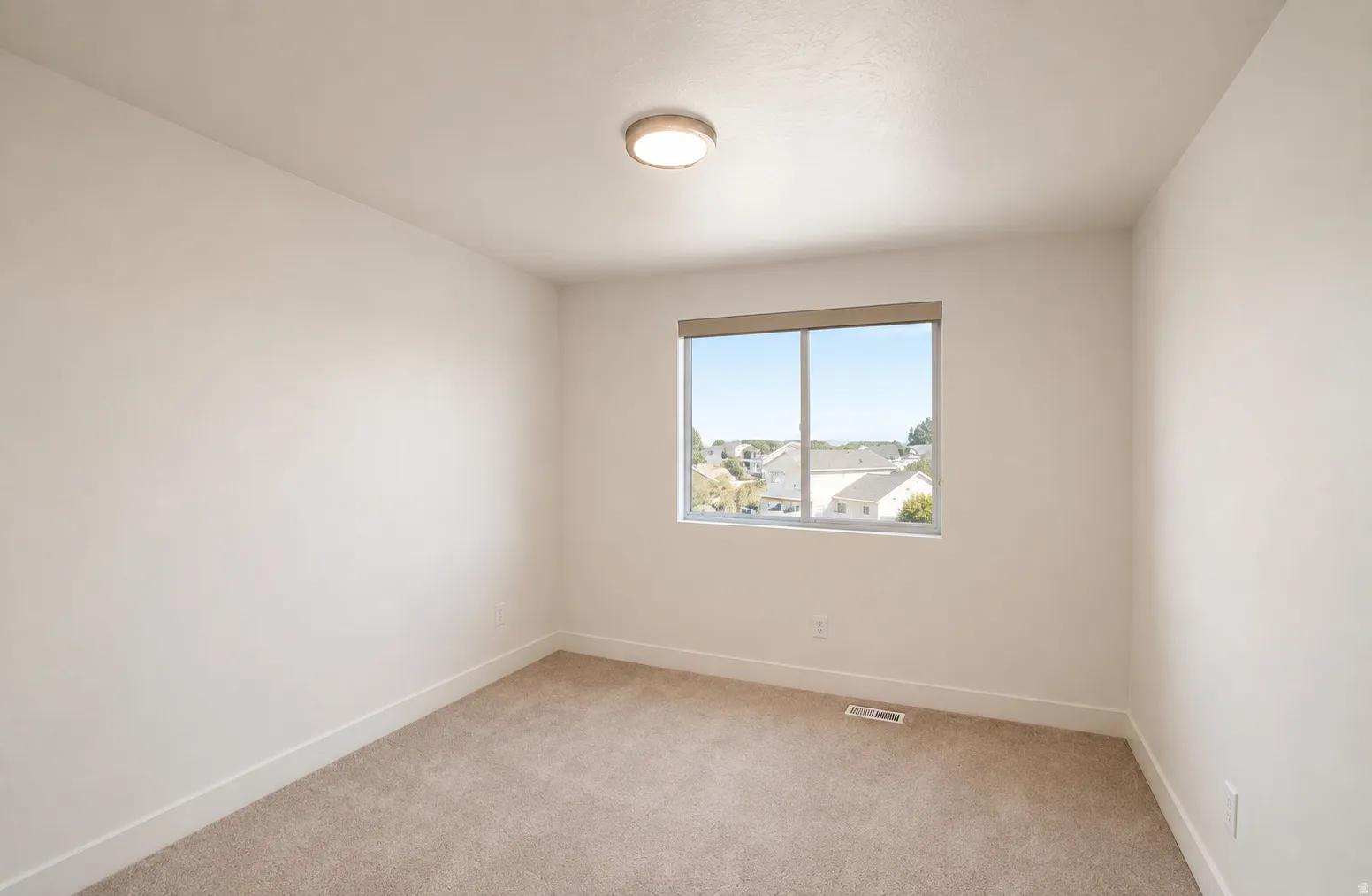 Neutral wall color, carpet flooring, recessed window, flush-mount ceiling light