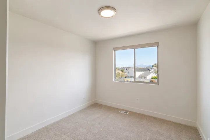 Neutral paint palette, recessed window, wall-to-wall carpeting, contemporary flush-mount ceiling light fixture, mountain backdrop